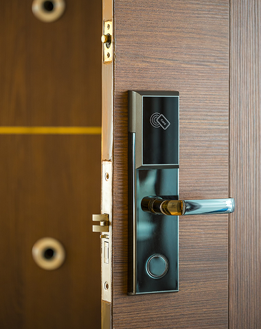 Modern door lock mechanism on a wooden door, illustrating security features relevant to locksmith services in emergency situations.