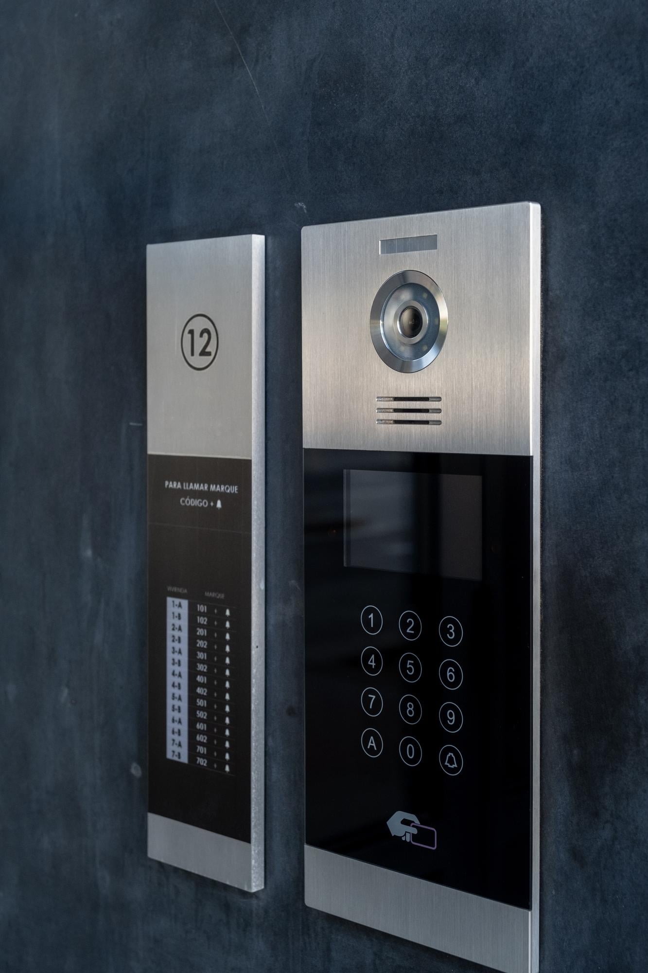 Modern intercom system with keypad and call button, featuring building number 12 and instructions for dialing, relevant to Houston Secure Locksmith's security solutions.